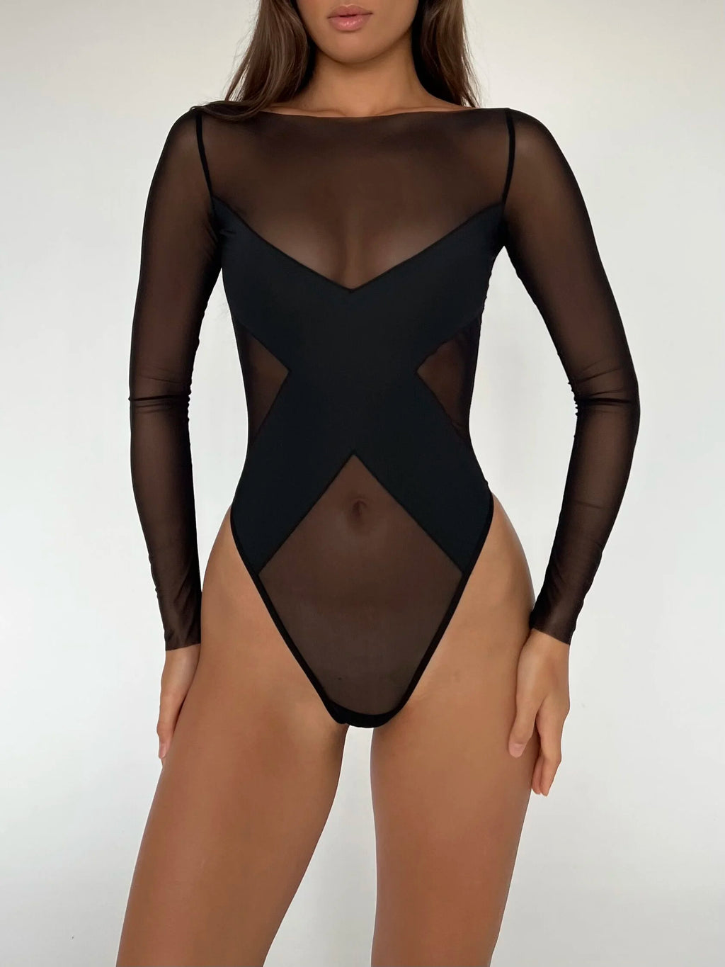 A black bodysuit with long sleeves and a provocative pattern covering the chest, modeled by a person.